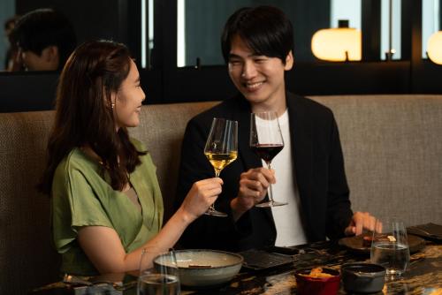 a man and woman sitting at a table with wine glasses at The Westin Yokohama in Yokohama