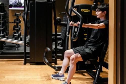 a man sitting in a gym doing squats at The Westin Yokohama in Yokohama