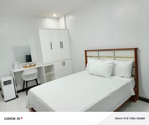 a white bedroom with a bed and a desk at EPM Tower Hotel and Events Place in Alfonso
