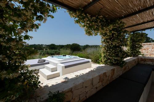 a garden with a hot tub on a stone wall at Trulli di Mezza in Cisternino
