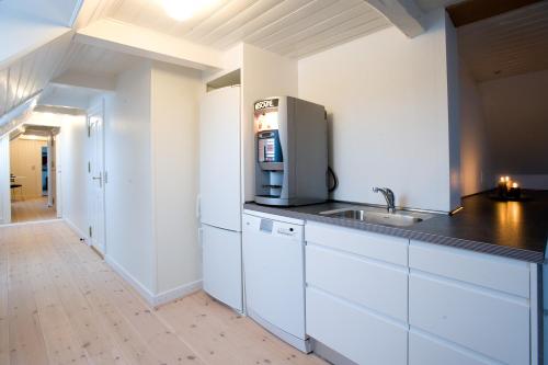 a kitchen with white cabinets and a sink at Den Gamle Købmandsgaard Bed & Breakfast in Ribe