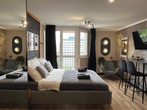Un dormitorio con una cama grande y una mesa y sillas. en Silesian Gold Apartments, en Katowice