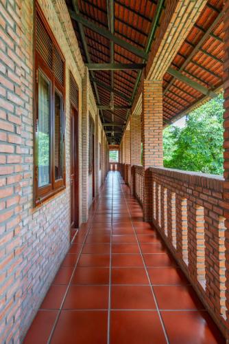 an empty porch of a brick building with awning and tile floor at Mekong Long Thanh Resort & Reststop in Ấp Thanh Nguyên