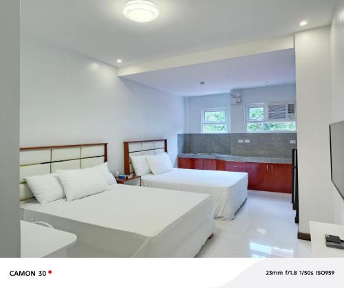a bedroom with two beds and a kitchen at EPM Tower Hotel and Events Place in Alfonso