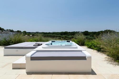 two beds on a patio with a hot tub at Trulli di Mezza in Cisternino