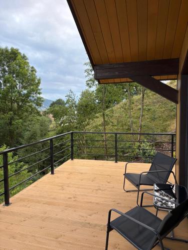 two chairs on a deck with a view of trees at Petrick House in Verkhovyna