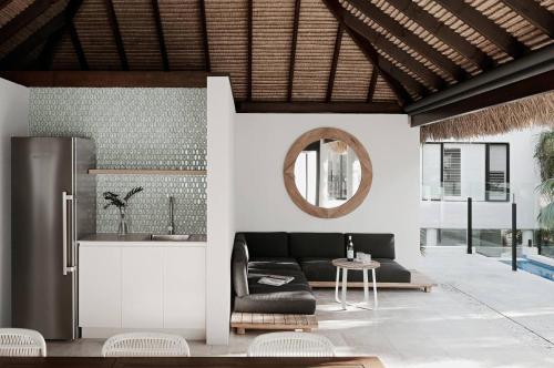 sala de estar con sofá negro y espejo en Elanda on Sunshine - Ocean views, see the whales, en Sunshine Beach