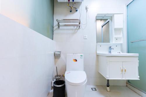 a white bathroom with a toilet and a sink at Shanghai Koala International Youth Hostel in Shanghai