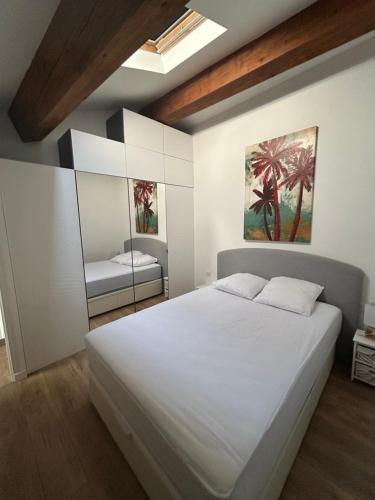 une chambre avec un grand lit blanc et un miroir dans l'établissement Charmant Duplex Centre Village, à Saint-Cyr-sur-Mer