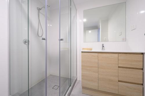 Un baño con ducha de cristal y lavabo. en 104 EastPerth Euphoria Escape 2BR Parkng, en Perth