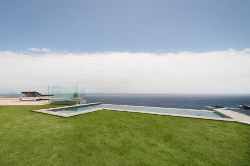 a glass house with a view of the ocean at V&C Luxury Village in Breña Baja