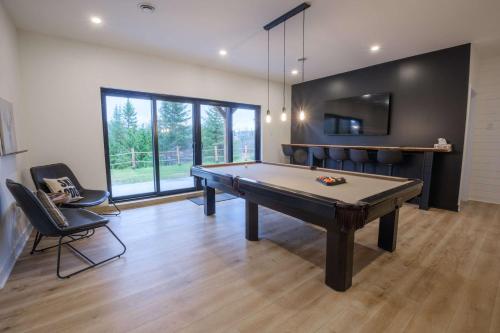 a room with a ping pong table and chairs at Spa & Pure Relaxation - Chalet Saint-Cerf in Saint Come