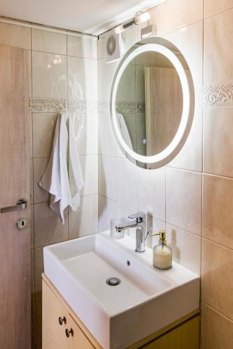 a bathroom with a white sink and a mirror at Gina's house in Asklipiḯon