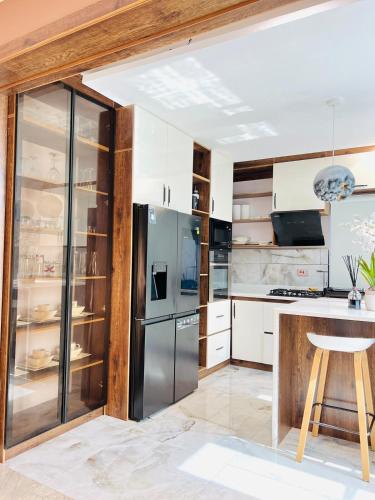 una cocina con nevera de acero inoxidable y armarios blancos en Vio Luxury Homes, en Ogoyo