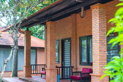 a brick house with two chairs on a patio at Mekong Long Thanh Resort & Reststop in Ấp Thanh Nguyên