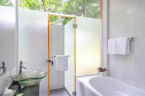 a bathroom with a bath tub and a sink at Mekong Long Thanh Resort & Reststop in Ấp Thanh Nguyên