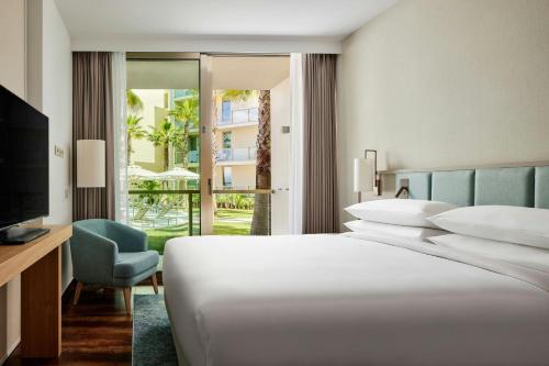 a bedroom with a bed and a television and a chair at Marriott Residences Salgados Resort, Algarve in Albufeira