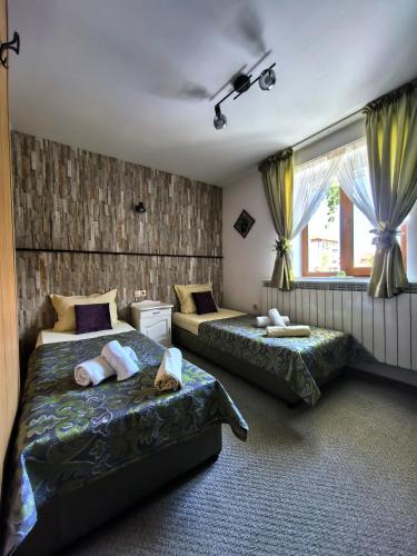a bedroom with two beds and a window at Zigen House in Bansko