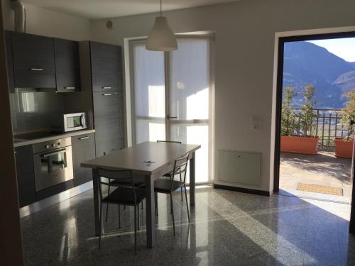 a kitchen with a table and chairs and a balcony at Casa Lampone in Trento