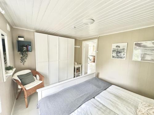 a bedroom with a bed and a chair at Panoramablick - Meer - Familien - Remote Work in Fjällbacka