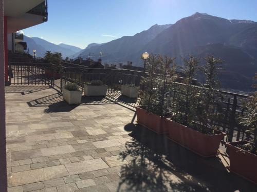 a balcony with potted plants and a railing with mountains at Casa Lampone in Trento