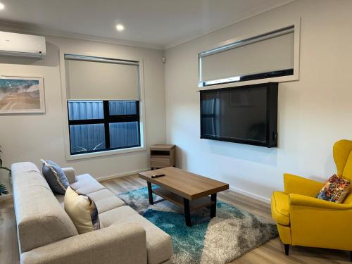 a living room with a couch and a tv at Special Retreat-Beveridge in Beveridge
