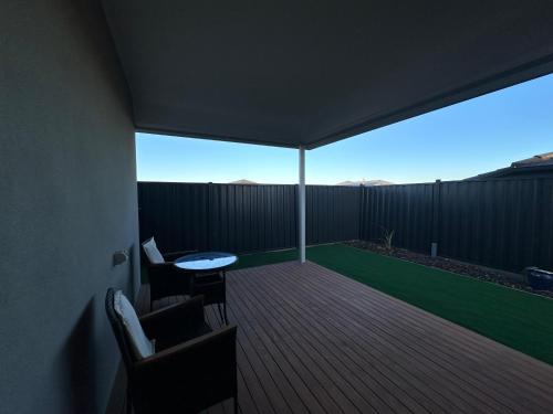 a patio with a table and chairs on a deck at Special Retreat-Beveridge in Beveridge