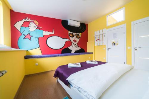 a bedroom with a bed with a painting on the wall at Апартаменты WOW-hotel in Kyiv