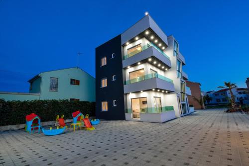 a large black building with a playground in front of it at Boutique Apartments Ad Astra in Bibinje