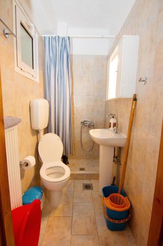 a bathroom with a toilet and a sink at Limnos Family Studios in Angariónes