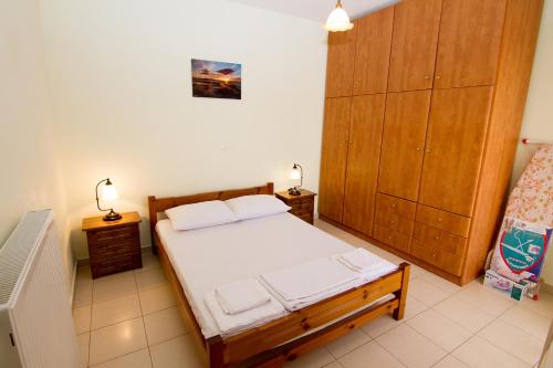a bedroom with a bed and a wooden cabinet at Limnos Family Studios in Angariónes