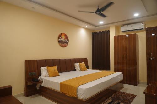 a bedroom with a bed and a ceiling fan at Raj Kamal Hotel & Garden in Gwalior