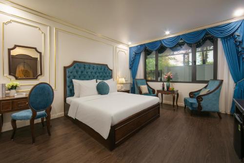 a bedroom with a bed and two chairs and a mirror at Royal Dương Nội Hotel in Hanoi