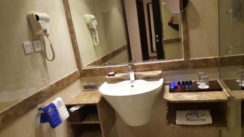 a bathroom with a sink and a mirror and a phone at Qasr Al Sahab in Khamis Mushayt