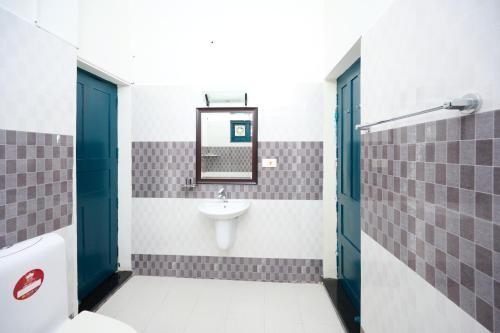 a bathroom with a sink and a mirror at Seclude by the Lake, Alleppey in Alleppey
