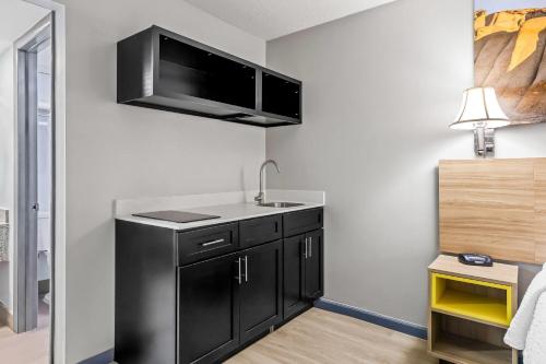 a kitchen with a sink and a black refrigerator at Days Inn by Wyndham Salina South in Salina