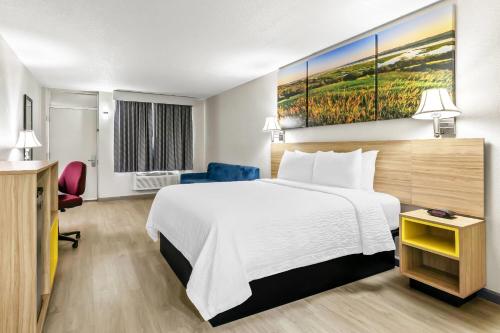 a hotel room with a large bed and a desk at Days Inn by Wyndham Salina South in Salina