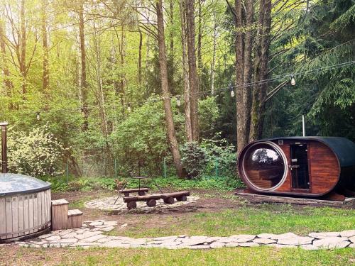 a round cabin in a forest with a picnic table at CzillasOrle luksusowy dom nad samym brzegiem jeziora Orle koło Augustowa in Płaska