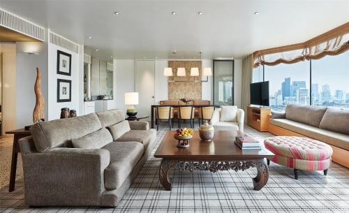 ein Wohnzimmer mit einer Couch und einem Tisch in der Unterkunft Grand Hyatt Erawan Bangkok in Bangkok