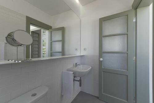 bagno bianco con lavandino e specchio di Embaixador 26: Belem Serviced Apartments a Lisbona