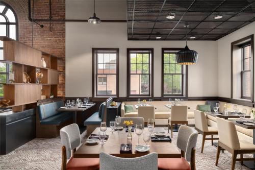 a restaurant with tables and chairs and windows at Hilton Garden Inn Burlington Downtown in Burlington
