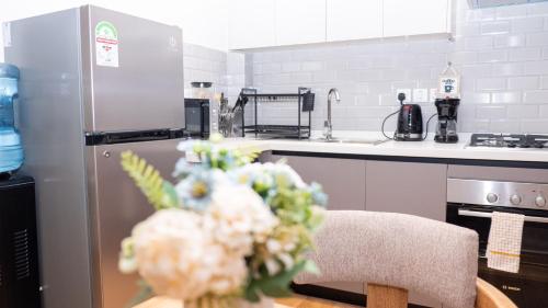 SkyView Haven by Seluveto Homes في نيروبي: مطبخ مع طاولة مع إناء من الزهور