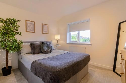 a bedroom with a bed and a window at Stunning 4-bed Home in Milton Keynes by Renzo, Swimming Pool, Games Room! in Bletchley