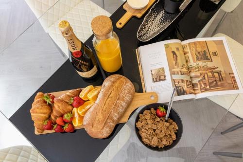 a table topped with a plate of food and a book at Stunning 4-bed Home in Milton Keynes by Renzo, Swimming Pool, Games Room! in Bletchley