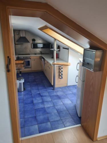 a small kitchen with a blue tiled floor at HOTEL Jerolitsch in Krumpendorf am Wörthersee