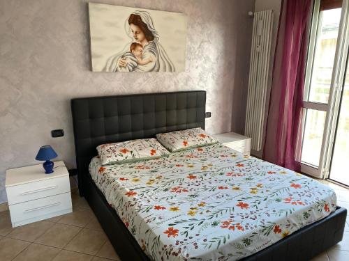 a bedroom with a bed and a painting on the wall at I colori della casa di Gio in Grugliasco