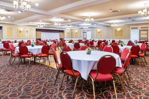 a conference room with tables and red chairs at Rodeway Inn Festival in Stratford