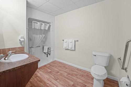 a bathroom with a toilet and a sink at Days Inn by Wyndham Lamont in Lamont
