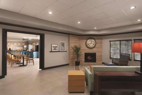 a waiting room with a fireplace and a clock on the wall at Country Inn & Suites by Radisson Raleigh-Durham Airport NC in Morrisville