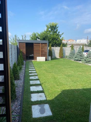 a garden with grass and stones in front of a building at вулиця 8-го Березня Апартаменты in Myrhorod